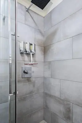 a shower with a glass door in a bathroom at Athena’s Hideaway- Fully Renovated- Absolute Best Location in Athens