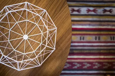 a white geometric object on a wooden table next to a rug at Athena’s Hideaway- Fully Renovated- Absolute Best Location in Athens