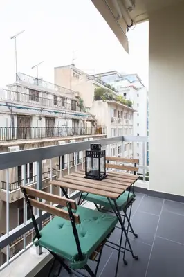 a table and chairs on a balcony with a view of buildings at Athena’s Hideaway- Fully Renovated- Absolute Best Location in Athens