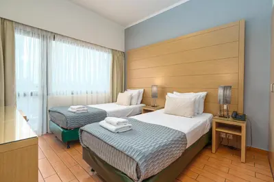 a hotel room with two beds and a window at Parnon Hotel in Athens