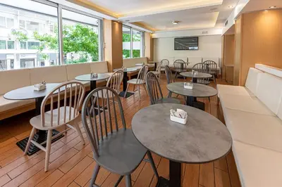 a restaurant with tables and chairs and windows at Parnon Hotel in Athens