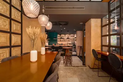 a restaurant with a large wooden table and chairs at Parnon Hotel in Athens