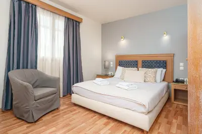 a bedroom with a bed and a chair and a desk at Parnon Hotel in Athens