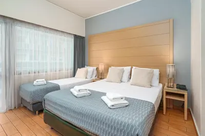 two beds in a hotel room with towels on them at Parnon Hotel in Athens