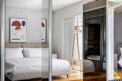 a bedroom with a white bed and a mirror at Acropolis Breathtaking View in Athens