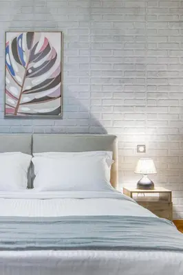 a bedroom with a bed and a painting on the wall at Acropolis Breathtaking View in Athens