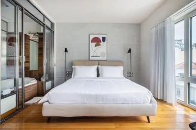 a bedroom with a white bed and a large window at Acropolis Breathtaking View in Athens