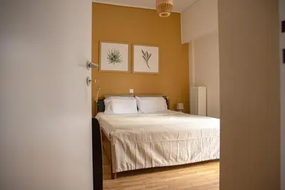 a bedroom with a bed with two pictures on the wall at 3C's-Central, Cosy, Convenient to Airport 24/7 in Athens