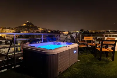 a hot tub on the deck of a cruise ship at night at Majestic Acropolis-Lycabettus in Athens