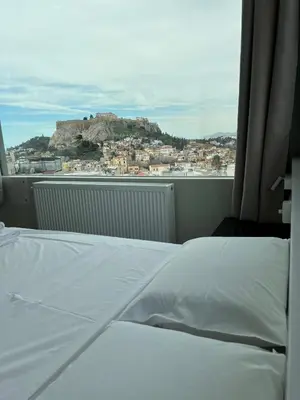 a bed in a room with a view of a mountain at Majestic Acropolis-Lycabettus in Athens