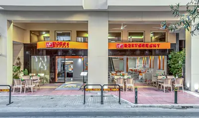 a restaurant with tables and chairs in front of a building at Faros I in Piraeus