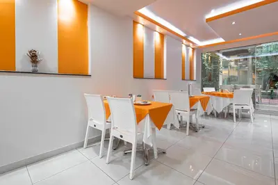 a dining room with yellow tables and white chairs at Faros I in Piraeus