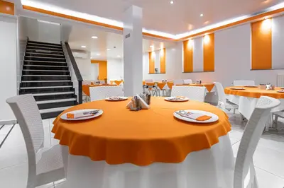 a dining room with an orange table and chairs at Faros I in Piraeus
