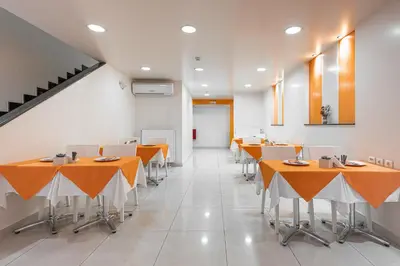 a dining room with orange tables and chairs at Faros I in Piraeus