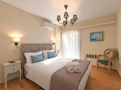 a bedroom with a large white bed with blue pillows at Penthouse Apartment & Studio near Glyfada - free Parking in Athens