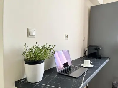 a laptop on a counter with a plant and a cup of coffee at Penthouse Apartment & Studio near Glyfada - free Parking in Athens