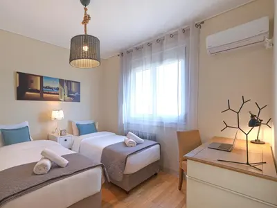 a hotel room with two beds and a desk at Penthouse Apartment & Studio near Glyfada - free Parking in Athens