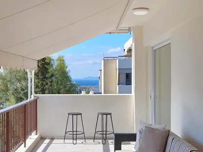 a balcony with two bar stools and a view at Penthouse Apartment & Studio near Glyfada - free Parking in Athens