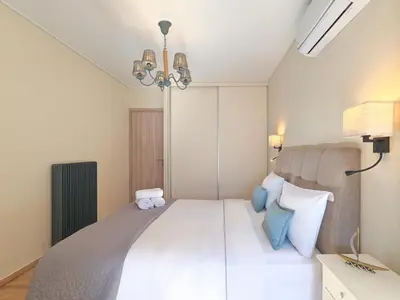 a bedroom with a large white bed with blue pillows at Penthouse Apartment & Studio near Glyfada - free Parking in Athens
