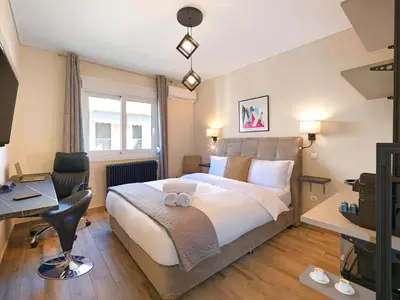 a hotel room with a bed and a desk at Penthouse Apartment & Studio near Glyfada - free Parking in Athens