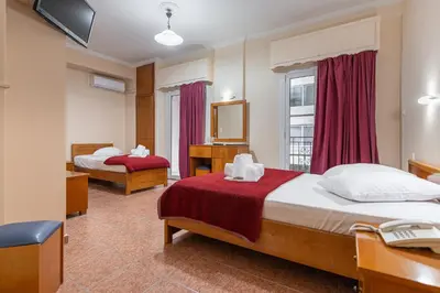 a hotel room with two beds and a mirror at Faros II in Piraeus