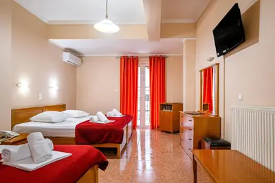 a hotel room with two beds and a flat screen tv at Faros II in Piraeus