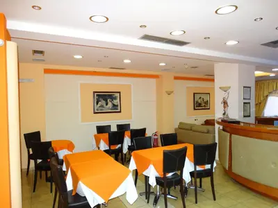 a dining room with orange tables and chairs at Faros II in Piraeus