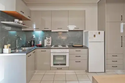a kitchen with white appliances and a white refrigerator at Ella Suite Piraeus Stylish St, Balcony & Sea View in Piraeus