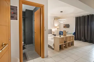 a bedroom with a bed and a table and a mirror at Ella Suite Piraeus Stylish St, Balcony & Sea View in Piraeus