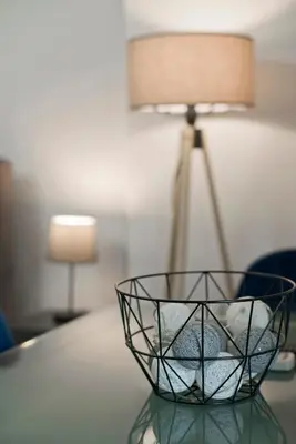 a wire basket sitting on a table with a lamp at Ella Suite Piraeus Stylish St, Balcony & Sea View in Piraeus