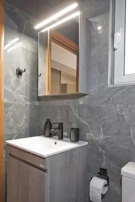 a bathroom with a sink and a mirror at Ella Suite Piraeus Stylish St, Balcony & Sea View in Piraeus
