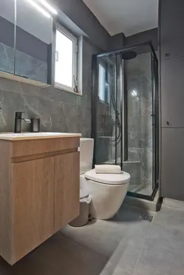 a bathroom with a shower and a toilet and a sink at Ella Suite Piraeus Stylish St, Balcony & Sea View in Piraeus