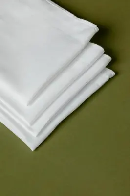 a stack of white napkins on a green table at Metropolis A1-Γοητευτική Σουίτα in Athens