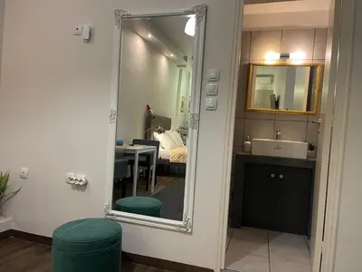 a bathroom with a mirror and a sink and a bedroom at Metropolis A1-Γοητευτική Σουίτα in Athens
