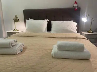 a bedroom with a large bed with two towels on it at Metropolis A1-Γοητευτική Σουίτα in Athens