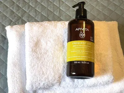 a bottle of shampoo sitting on a towel at Metropolis A1-Γοητευτική Σουίτα in Athens