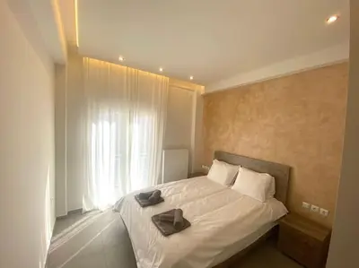a bedroom with a bed with a pair of shoes on it at Piraeus Apartment for rent in Piraeus