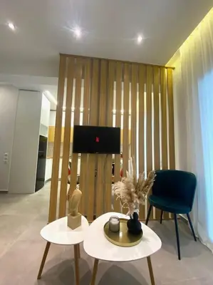 a living room with two tables and a chair at Piraeus Apartment for rent in Piraeus