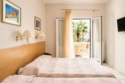 a bedroom with a bed and a large window at Katerina Hotel in Agia Marina Aegina