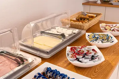 a table with plates of food and bowls of food at Katerina Hotel in Agia Marina Aegina