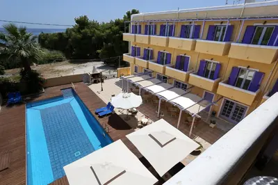 a hotel with a swimming pool and a building at Katerina Hotel in Agia Marina Aegina