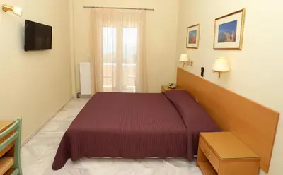 a hotel room with a bed and a window at Katerina Hotel in Agia Marina Aegina