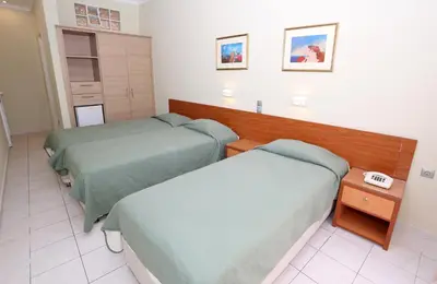 a hospital room with two beds and a table at Katerina Hotel in Agia Marina Aegina