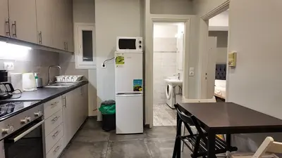 a kitchen with a refrigerator and a table in it at Athens City Themis 8 in Athens