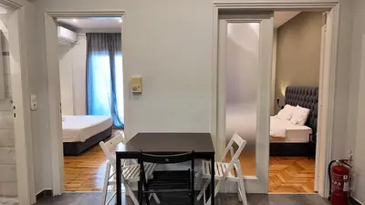 a room with a table and chairs and a bedroom at Athens City Themis 8 in Athens