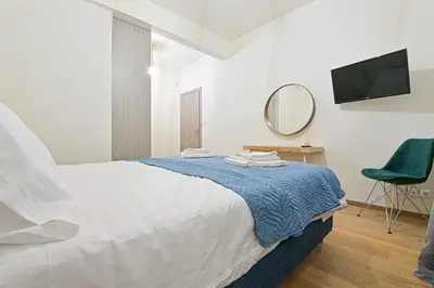 a white bedroom with a bed and a mirror at Areos Comfort Living Apartment - Alexandras Ave 72 in Athens