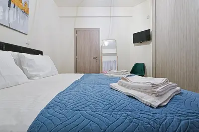 a bedroom with a bed with towels on it at Areos Comfort Living Apartment - Alexandras Ave 72 in Athens