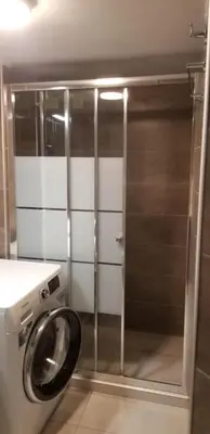 a bathroom with a washing machine in a room at Areos Comfort Living Apartment - Alexandras Ave 72 in Athens