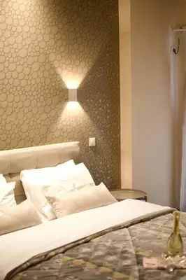 a bedroom with a bed with a light on the wall at Minoa Athens Hotel in Athens