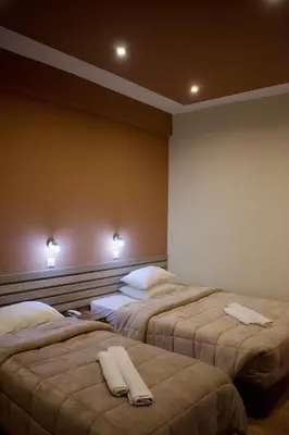 a room with three beds with white towels on them at Nafsika Hotel Athens Centre in Athens